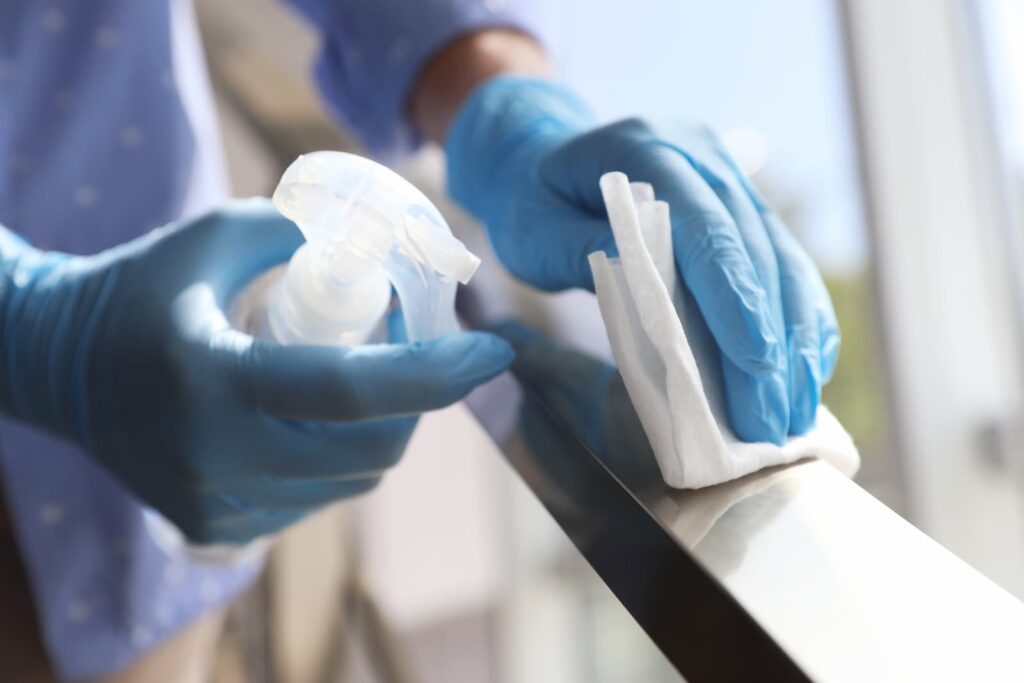 woman-in-latex-gloves-cleaning-railing